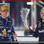 Max Verstappen and race engineer Gianpiero Lambiase celebrating with trophies on the podium in Red Bull Racing gear