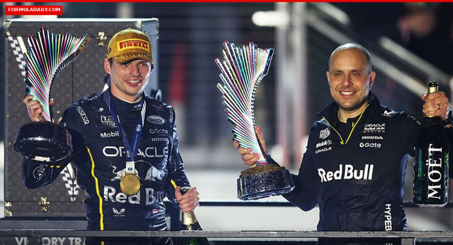 Max Verstappen and race engineer Gianpiero Lambiase celebrating with trophies on the podium in Red Bull Racing gear